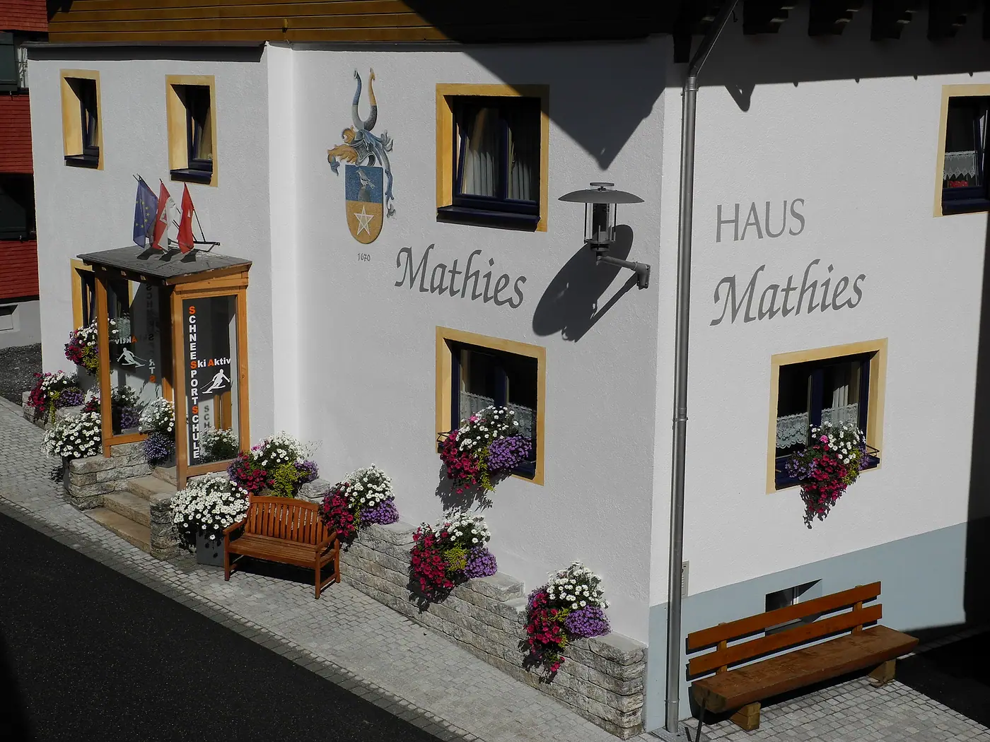 Haus Mathies in Stuben: weiße Fassade mit dem Schriftzug Haus Mathies, Blumen an den Fenstern